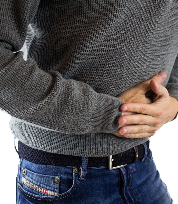 Hombre tocándose el abdomen con dolor por gastritis