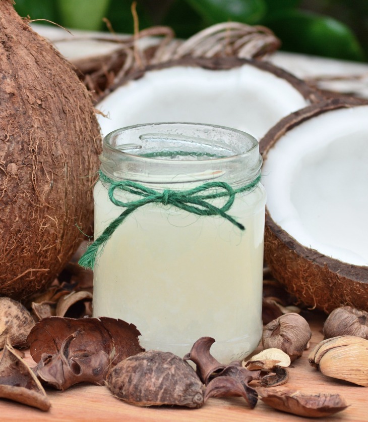 Coco natural partido y frasco con aceite de coco